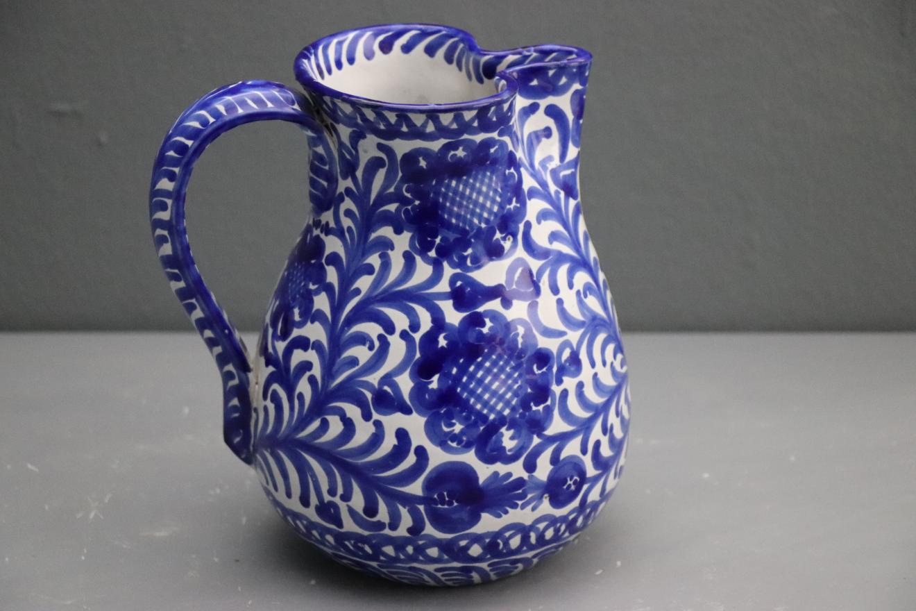 Jarra con decoración vegetal azul sobre fondo blanco